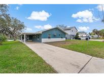 Charming single story home with teal and white paint, covered parking, and long driveway at 4638 Heavens Way, New Port Richey, FL 34652