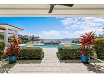 Inviting outdoor pool area with stunning waterfront views and lush landscaping provides the perfect backdrop for relaxation at 611 Brightwaters Ne Blvd, St Petersburg, FL 33704