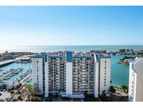 Expansive view of waterfront condo building with marina, ocean and harbor at 9525 Blind Pass Rd # 301, St Pete Beach, FL 33706