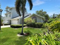 Charming two-story home featuring a well-manicured lawn with beautiful landscaping and a lush green yard at 11722 Currie Ln # G1, Largo, FL 33774