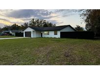Charming single-story home featuring a well-maintained lawn, dark fenced in yard and an attached two-car garage at 18614 San Rio Cir, Lutz, FL 33549