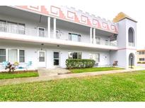 Three story condo building featuring white siding and a unique architectural design with a grassy lawn in front at 2100 World Parkway Blvd # 30, Clearwater, FL 33763