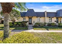 Charming townhouse featuring a unique roofline, well-maintained landscaping, and a welcoming entrance at 2101 Cordova Grn, Seminole, FL 33777