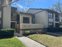 Condominium exterior featuring well-manicured lawn and visible unit numbers for easy identification at 233 Woodlake Wynde, Oldsmar, FL 34677