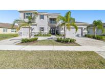 Elegant two-story home boasts a three-car garage and meticulous landscaping with lush palm trees at 3280 Juniper Springs St, Wesley Chapel, FL 33543
