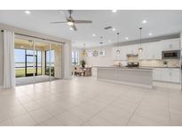 Spacious living room with an open floor plan, seamlessly connecting to the modern kitchen and screened patio with water views at 42211 Edgewater Dr, Punta Gorda, FL 33982