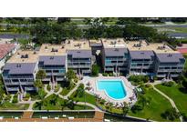 Overhead shot of condos with a community pool, complemented by lush greenery, and a waterfront dock at 936 Pinellas Bayway S # T-7, Tierra Verde, FL 33715