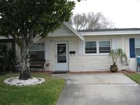 Charming single-story home with white brick, white shutters, well-maintained lawn and a mature shade tree at 9911 Dahlia N St # 38, Pinellas Park, FL 33782