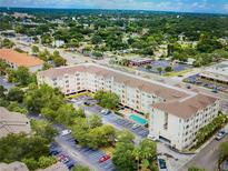 Aerial view of condo community with pool, parking and green space nestled among mature trees at 1216 S Missouri Ave # 321, Clearwater, FL 33756