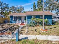 Charming blue single-story home featuring a cozy front porch and well-maintained landscaping at 1946 Springtime Ave, Clearwater, FL 33755