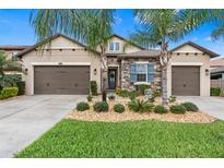 Charming home with a well manicured lawn, stone accents, complemented by swaying palm trees and a triple car garage at 4495 Casella Dr, Wesley Chapel, FL 33543