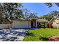 Charming single-story home featuring a well-maintained lawn, mature trees, and a two-car garage at 4967 162Nd N Ave, Clearwater, FL 33760