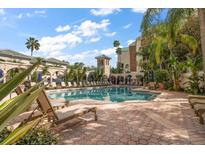 Resort-style pool area with ample lounge seating, lush landscaping, and tropical accents at 501 Knights Run Ave # 2101, Tampa, FL 33602