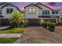 Attractive townhome showcasing brick paver driveway and two-car garage at 5087 San Martino Dr, Wesley Chapel, FL 33543