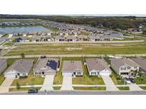 Spacious suburban neighborhood with manicured lawns, a scenic pond, and organized street layouts at 8034 Broad Pointe Dr, Zephyrhills, FL 33540