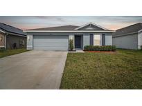 Charming single-story home features a two-car garage, manicured lawn and a cozy front entrance at 8034 Broad Pointe Dr, Zephyrhills, FL 33540