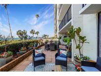 Relaxing patio area with lovely views of the water, potted plants, and comfortable seating at 100 Oakmont Ln # 112, Belleair, FL 33756