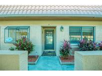 Inviting front entrance featuring a tiled walkway, lush landscaping, and a secure, modern front door at 19029 Us Highway 19 N # 29E, Clearwater, FL 33764