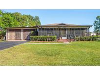 Charming home with a large front yard, screened porch and convenient detached garage at 2102 W Knights Griffin Rd, Plant City, FL 33565
