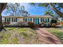 Charming single-story home with a brick walkway, a well-manicured lawn, and vibrant landscaping at 3810 W Granada St, Tampa, FL 33629