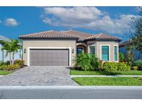 Charming single-Gathering home with a tile roof, paver driveway, and well-manicured landscaping at 6104 Talon Preserve Dr, Nokomis, FL 34275