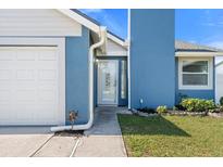 Charming home featuring a bright blue exterior, white garage door, and manicured lawn at 3525 65Th Avenue E Cir, Sarasota, FL 34243