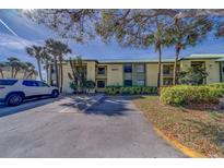 Well-maintained condo exterior featuring a tropical landscape and ample parking space at 6033 113Th St # 213, Seminole, FL 33772