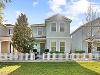 Charming two-story home features a well-manicured lawn and a classic white picket fence at 6157 Castleton Hollow Rd, Riverview, FL 33578