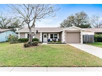 Charming single-story home featuring a well-manicured lawn and a cozy front porch with seating at 12162 Aurora Ct, Largo, FL 33774