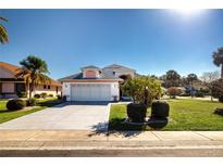 Well-maintained single-Gathering home featuring a two-car garage and landscaped front yard at 1601 E Del Webb Blvd, Sun City Center, FL 33573
