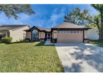 Inviting single-story home with a well-maintained lawn, a two-car garage, and attractive landscaping at 1728 Elk Spring Dr, Brandon, FL 33511