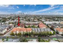 Aerial view of condo community with manicured lawns, colorful roofs, and a city skyline view at 2410 W Azeele St # 220, Tampa, FL 33609
