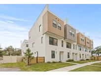 Modern townhouse featuring a white exterior, wood accents, and well-maintained landscaping in a desirable neighborhood at 305 15Th N St, St Petersburg, FL 33705