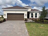 Charming single-story home with a two-car garage, manicured lawn, and beautiful landscaping at 3583 Santa Caterina Blvd, Bradenton, FL 34211