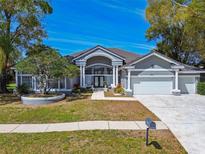 Stunning single-story home with meticulously maintained lawn and a three car garage at 3844 Wellington Pkwy, Palm Harbor, FL 34685