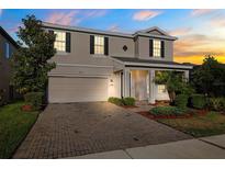 Charming two-story home featuring a well-manicured lawn and brick paved driveway at 4195 Welling Ter, Land O Lakes, FL 34638