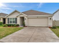Charming single-story home with a well-maintained lawn and a two-car garage at 7608 Broad Pointe Dr, Zephyrhills, FL 33540