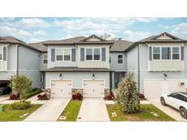 Charming townhome exterior featuring a two-car garage and beautifully landscaped front yard at 7782 93Rd N St, Seminole, FL 33777
