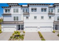 Beautiful three-story townhome features attached garages, well-maintained landscaping, and a contemporary design at 3025 Bermuda Sloop Cir, Ruskin, FL 33570