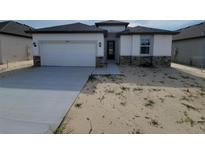 Modern one-story home with an attached garage and stone accents at 12631 Kelly Ann Loop, Brooksville, FL 34613