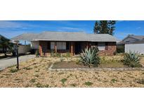 Charming brick home featuring desert-style landscaping and a covered carport at 1507 N Lake Dr, Sun City Center, FL 33573