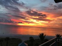 Beautiful sunrise over the ocean with orange and pink colors reflecting on the water and sand at 1520 Gulf Blvd # 805, Clearwater Beach, FL 33767