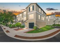 Attractive three-story townhome with a one-car garage surrounded by lush landscaping at 4405 Tuscan Loon Dr, Tampa, FL 33619
