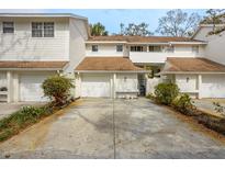 Charming townhome featuring white siding, a brown roof, attached garage and a well-maintained driveway at 5203 Bayshore Blvd # 5, Tampa, FL 33611