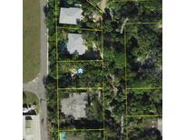 An aerial view of property surrounded by lush trees and a winding road. The view showcases the lot's neighborhood setting at 5218 Winding Way, Sarasota, FL 34242
