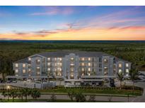 Three-story condo building with sunset, ample parking, and lush landscaping creating an inviting curb appeal at 14191 Heritage Landing Boulevard # 1234, Punta Gorda, FL 33955