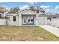 Charming single-Gathering home with a well-manicured lawn and inviting front porch featuring colorful chairs at 4104 E Comanche Ave, Tampa, FL 33610