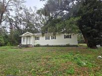 Quaint single-story home featuring a classic design, complemented by a lush front yard and mature trees at 5439 County Road 579, Seffner, FL 33584