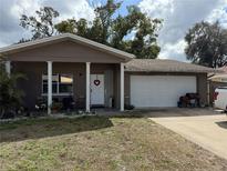 Charming single-story home with welcoming front porch, two car garage, and well-maintained lawn at 7534 Scottie Dr, Port Richey, FL 34668