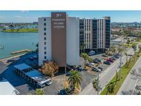 Daytime shot of Paradise Island Towers shows the building, parking lot, and surrounding landscape at 10355 Paradise Blvd # 614, Treasure Island, FL 33706